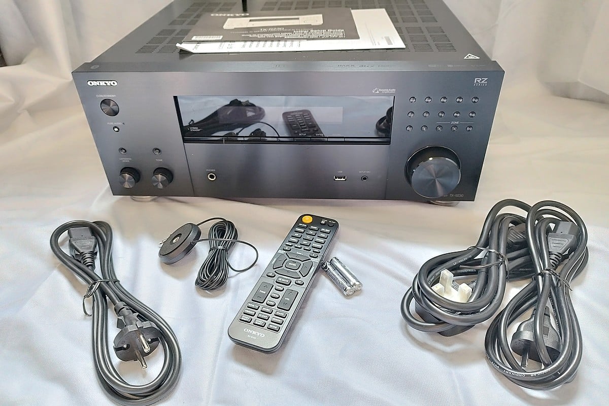 Vue d'ensemble du contenu du colis de l'ampli home-cinéma Onkyo TX-RZ30 : câbles, télécommande et micro de calibration.