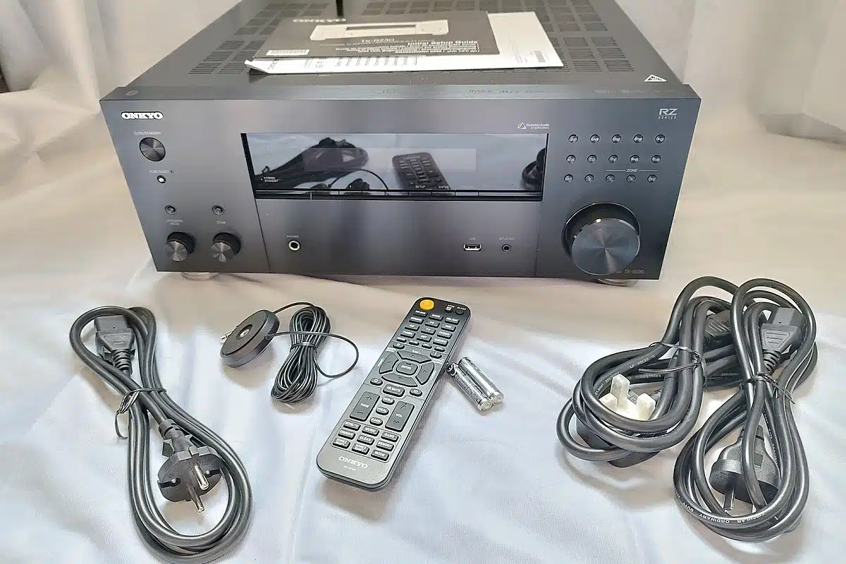 Vue d'ensemble du contenu du colis de l'ampli home-cinéma Onkyo TX-RZ30 : câbles, télécommande et micro de calibration.