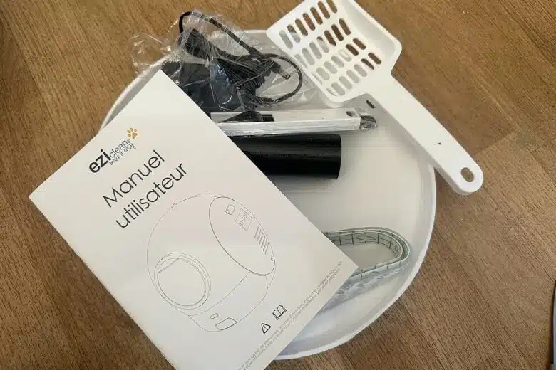 Le contenu du colis de la litière connectée EziClean K10i : manuel, accessoires, adaptateur secteur et pelle de secours.