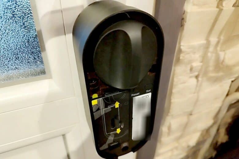 La partie intérieure de la serrure Aqara U200 fixée à la porte, prête à être utilisée, avec les stickers de configuration visibles.