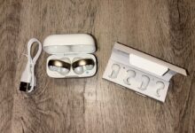 Les Soundcore AeroClip by Anker en rose cuivré et blanc, bien installés dans leur boîtier, prêts à être testés.