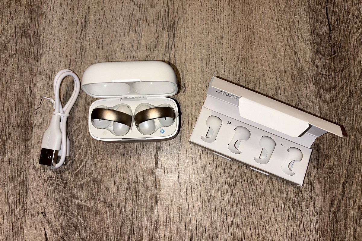 Les Soundcore AeroClip by Anker en rose cuivré et blanc, bien installés dans leur boîtier, prêts à être testés.