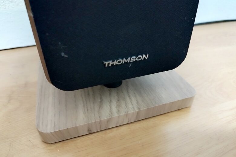 Détail de la base en bois et du logo discret des tours de son lumineuses cosy Thomson DS702, pour une finition élégante.