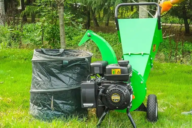 Un broyeur de végétaux thermique transforme des branches en paillage.