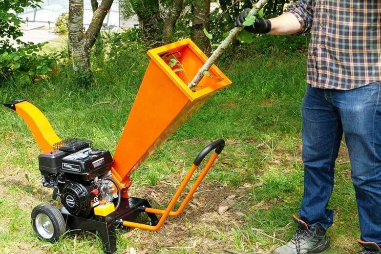 Un homme utilise un broyeur de végétaux.