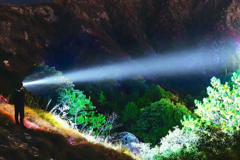 Une personne avec une lampe frontale dans la nature.