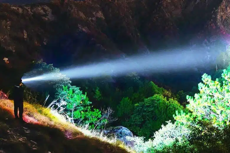 Une personne avec une lampe frontale dans la nature.