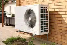 Une pompe à chaleur contre le mur du garage.
