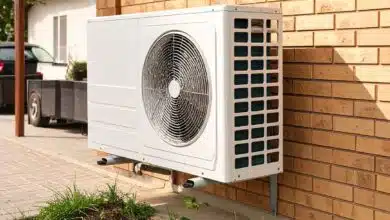 Une pompe à chaleur contre le mur du garage.