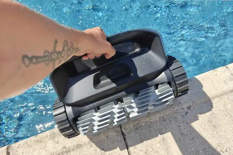 Un homme remonte son robot nettoyeur de la piscine.