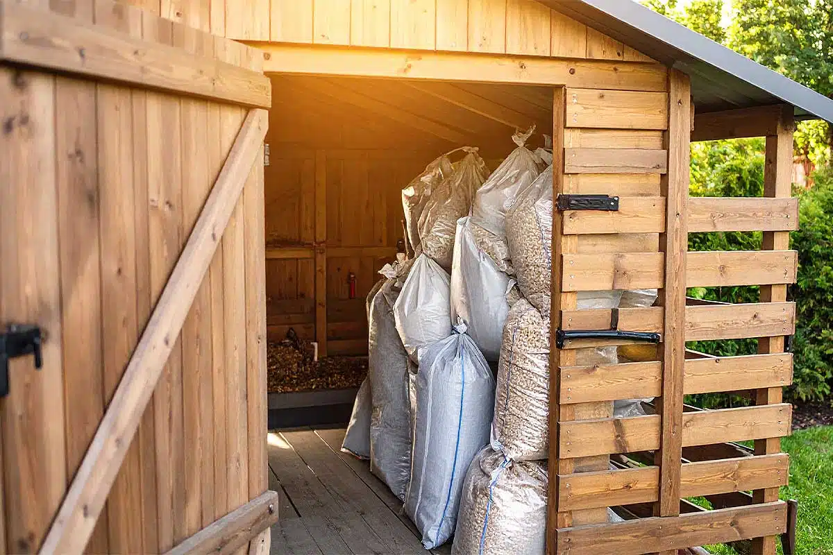 Un abri de jardin avec des sacs de pellets.