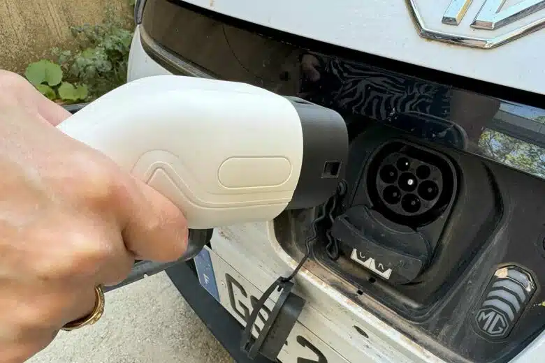 Une voiture électrique et sa prise de rechargement.