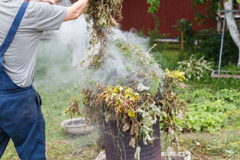 Une personne brule ses déchets vert.