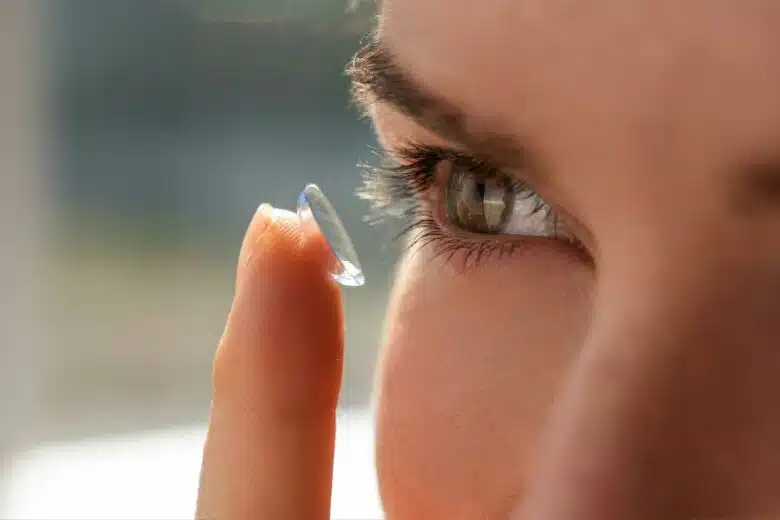 Une femme met une lentille de contact.