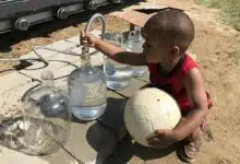 Un enfant se sert de l'eau.