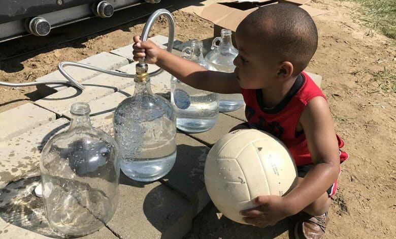 Un enfant se sert de l'eau.