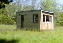 Une tiny house au milieu d'un pré.