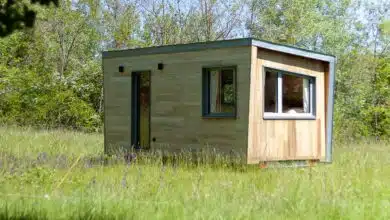Une tiny house au milieu d'un pré.