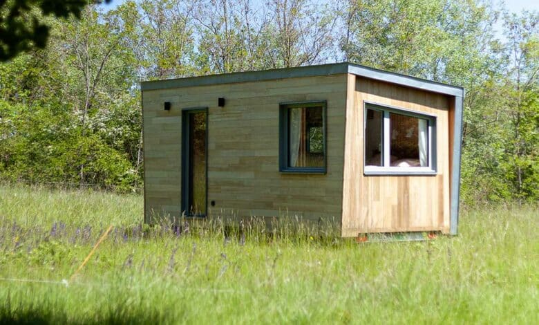 Une tiny house au milieu d'un pré.