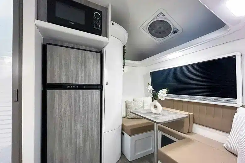 Une caravane équipée d'un grand frigo et d'un micro-ondes.