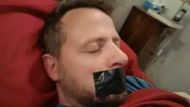 Un homme dort la bouche scotchée.
