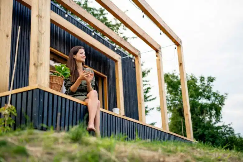 Une femme sur la terrasse de sa maison conteneur.