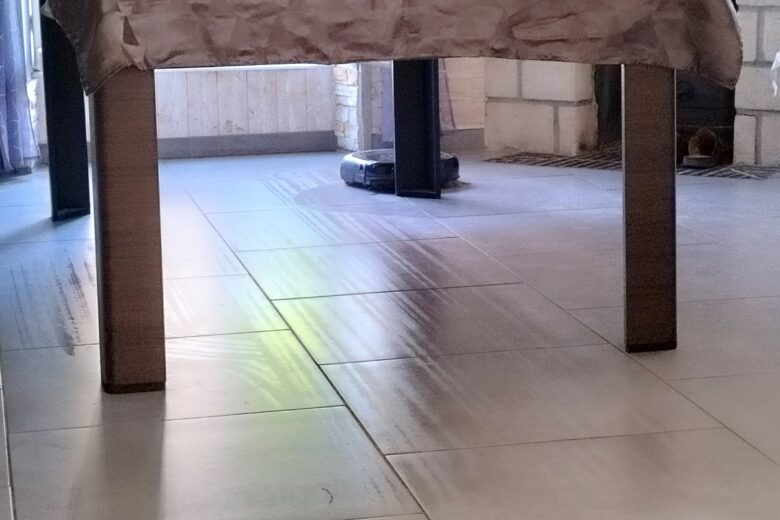Le Eufy E28 Omni nettoie le sol sous la table : des patins rotatifs qui laissent des traces nettes… de propreté.