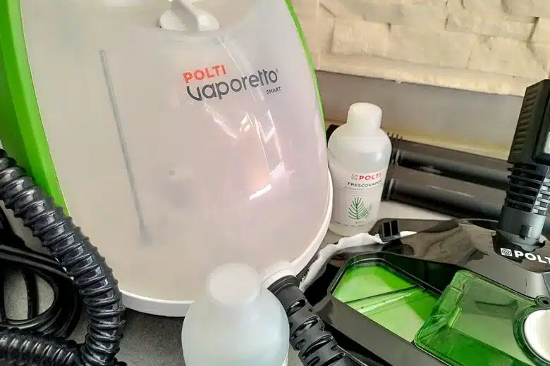 Zoom sur le réservoir translucide du Polti Vaporetto Smart110 Eco et les flacons de parfum d’ambiance Frescovapor fournis.