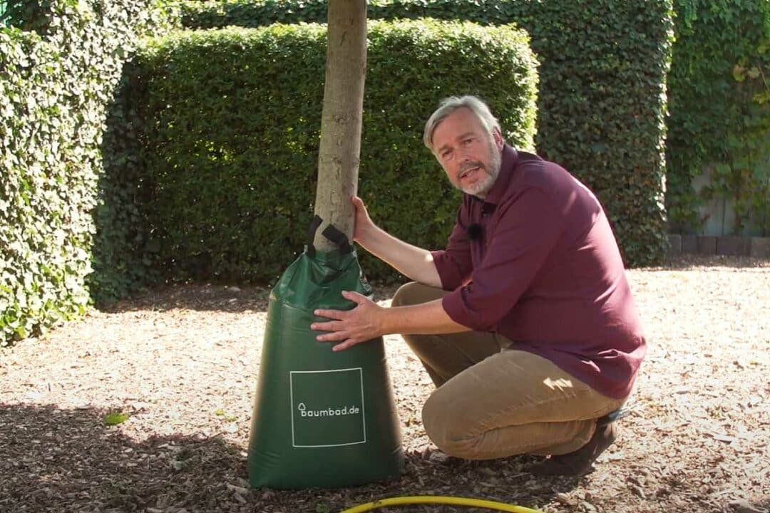 Un homme présente un sac d'irrigation.