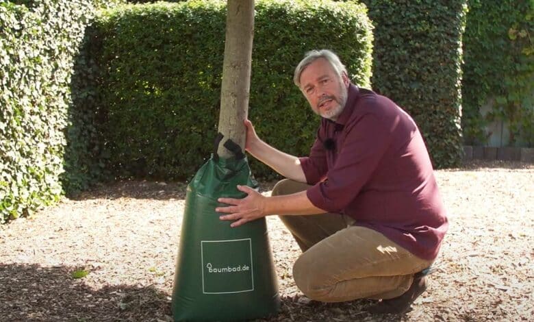 Un homme présente un sac d'irrigation.