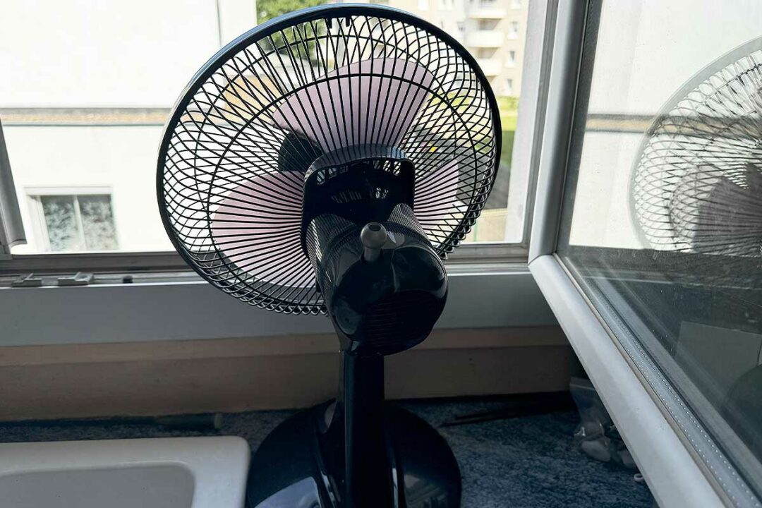 Un ventilateur face à une fenêtre.