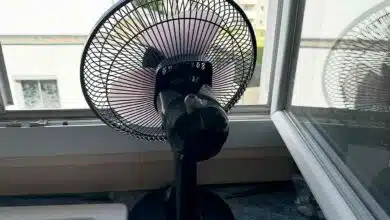 Un ventilateur face à une fenêtre.