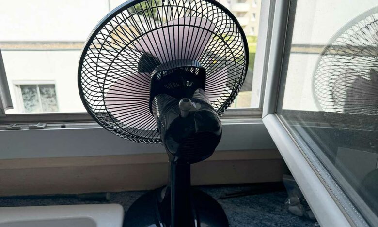 Un ventilateur face à une fenêtre.