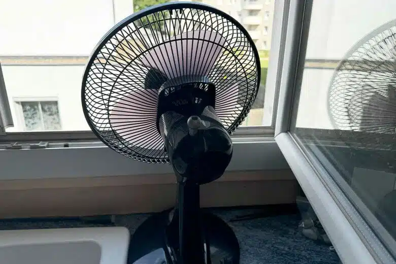 Un ventilateur face à une fenêtre.