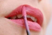 Une femme se remet du rouge à lèvres.
