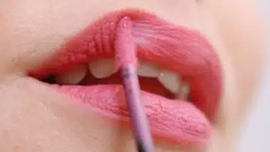Une femme se remet du rouge à lèvres.