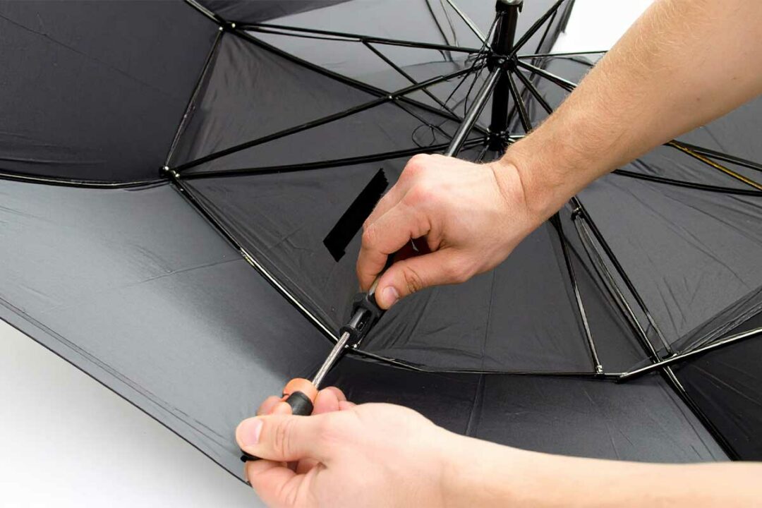 Un homme répare un parapluie.