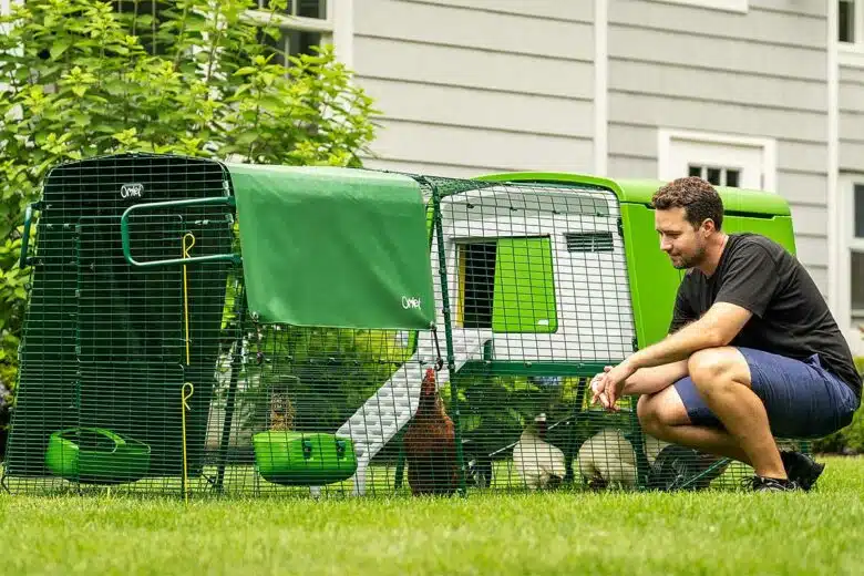 Un homme à côté de son poulailler.