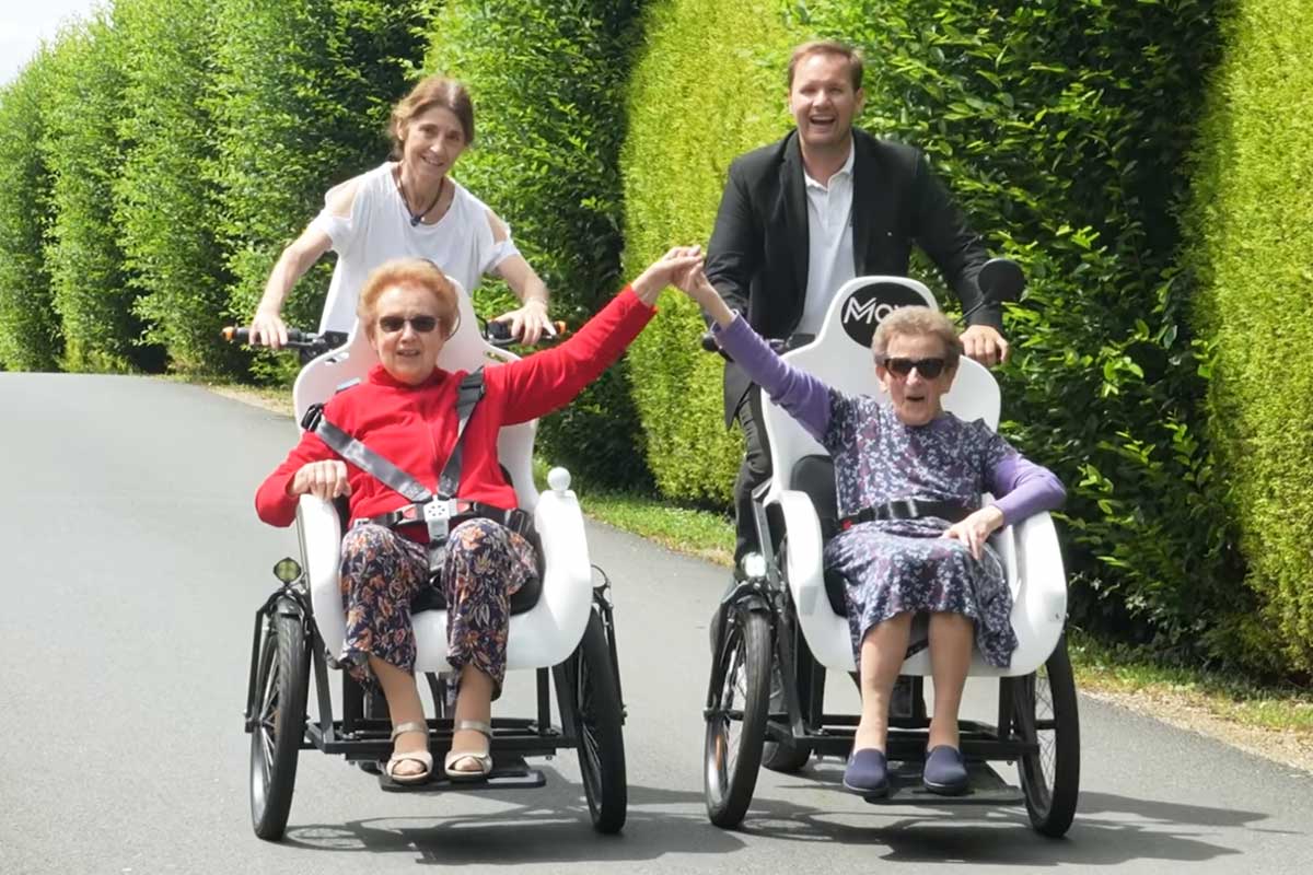 Des séniors en balade sur un triporteur.