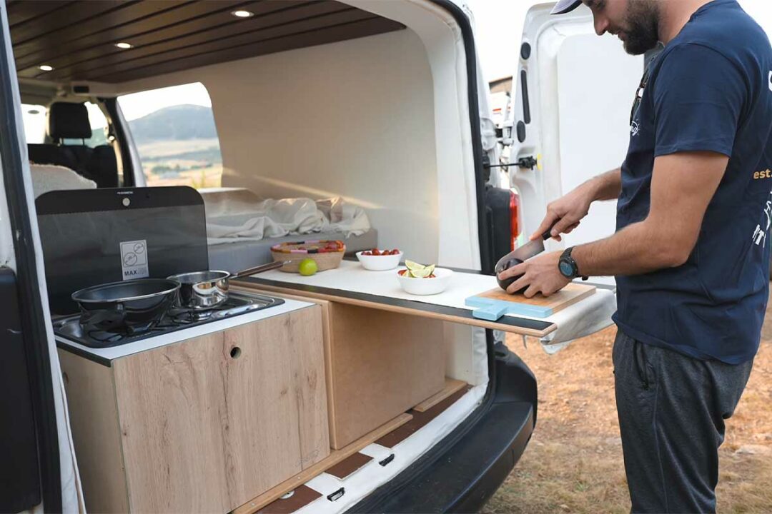 Préparation d'un repas avec le van aménagé.
