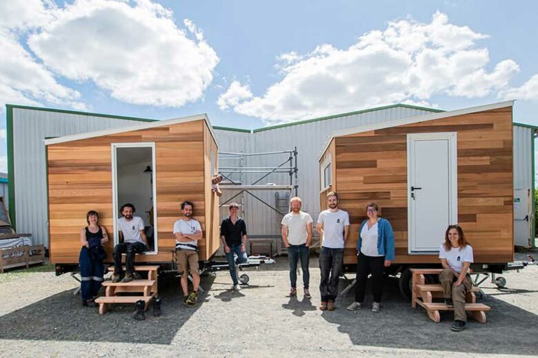 Des bénévoles de l'Association Solidarités Créations devant les deux tiny house pour abriter des femmes dans le besoin.