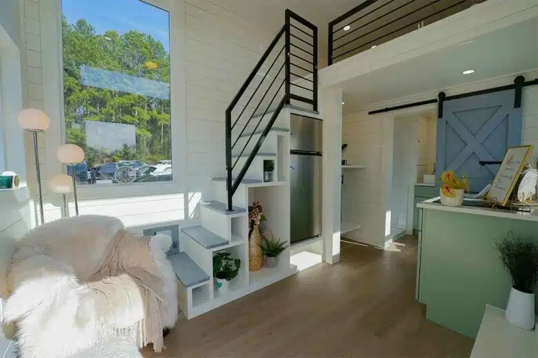 Un escalier pour accéder à la mezzanine avec des rangements et une penderie.