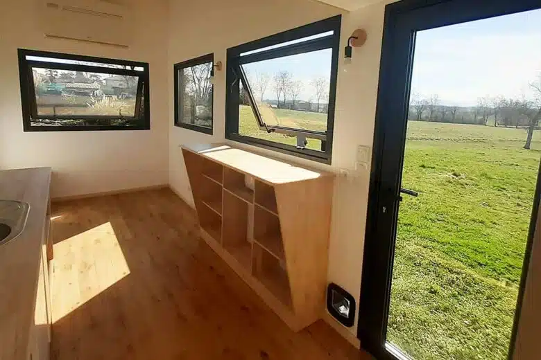 Une tiny house avec de grandes fenêtres.
