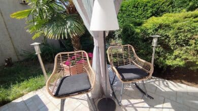Le lampadaire EZIlight Solar Lamp XL entre deux fauteuils de terrasse, pour des moments lecture ou détente en lumière douce.