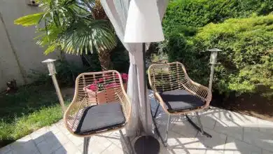 Le lampadaire EZIlight Solar Lamp XL entre deux fauteuils de terrasse, pour des moments lecture ou détente en lumière douce.
