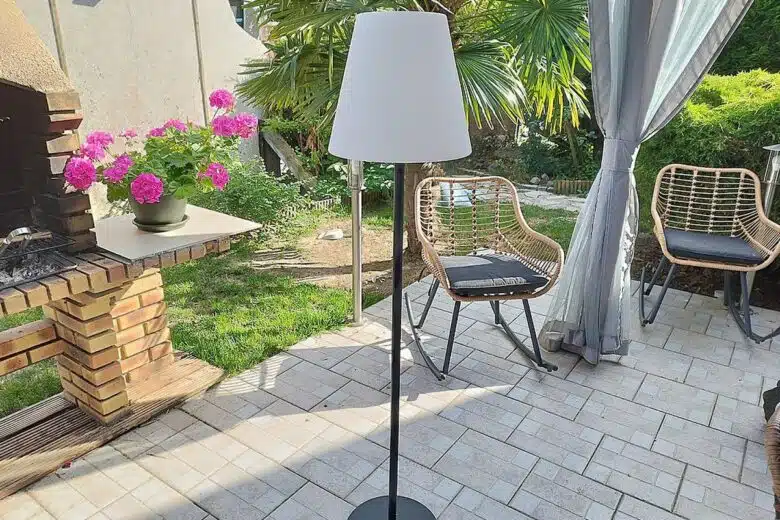 Le lampadaire EZIlight Solar Lamp XL installé sur une terrasse ombragée : design épuré et belle hauteur pour un usage extérieur.