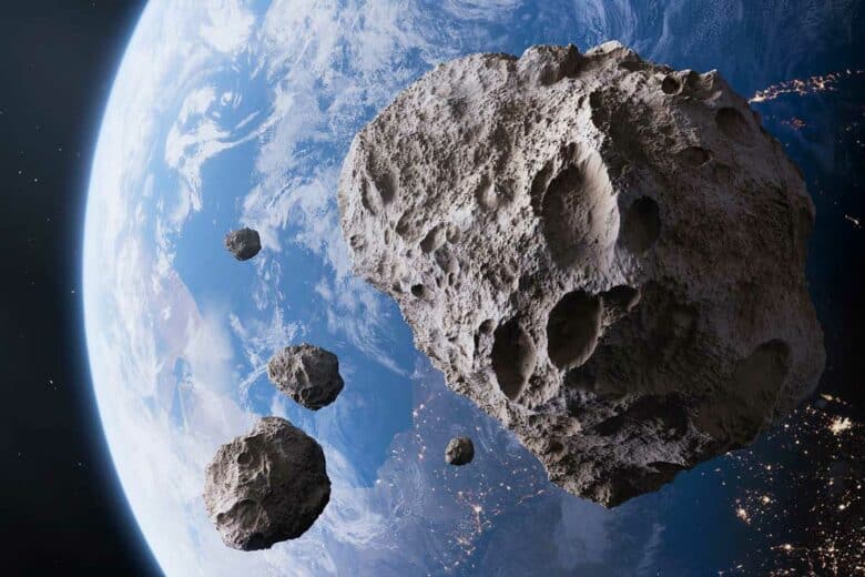 Des astéroïdes avec la Terre en arrière-plan.