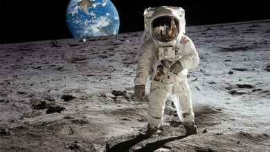 Un astronaute marche sur la Lune avec la Terre en fond.
