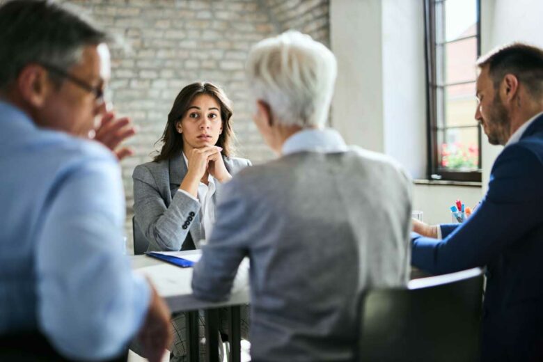Une femme lors d'un entretien face à des recruteurs.