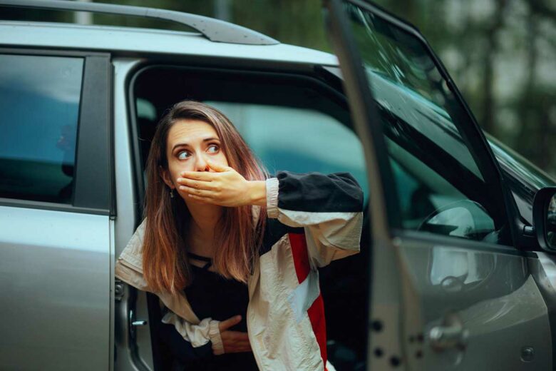 Une femme malade sort d'une voiture.